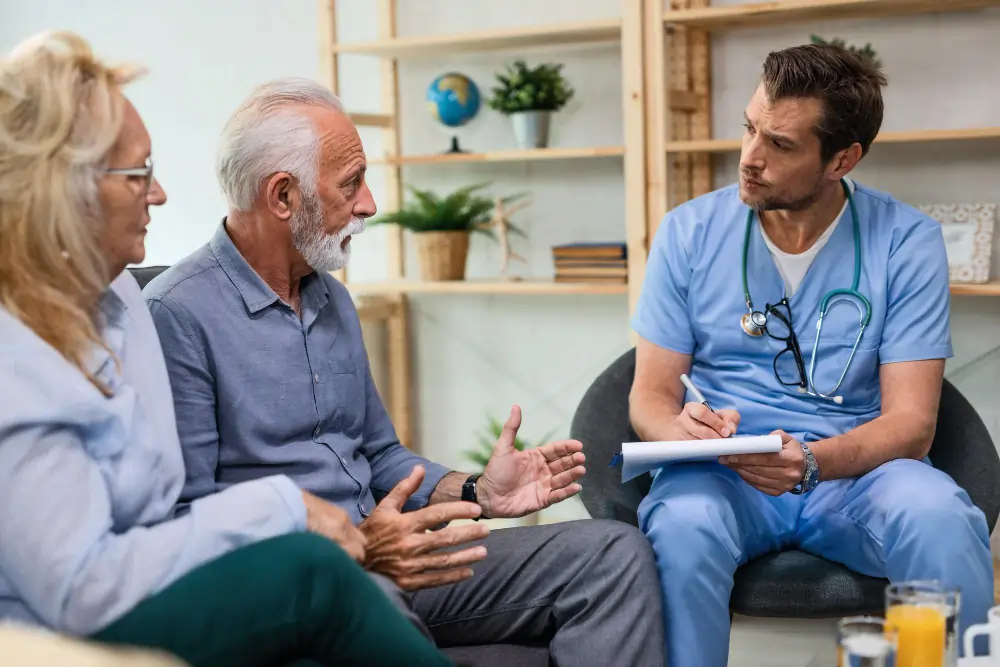 medical team representative sitting near old couples discussing their annual medical issues
